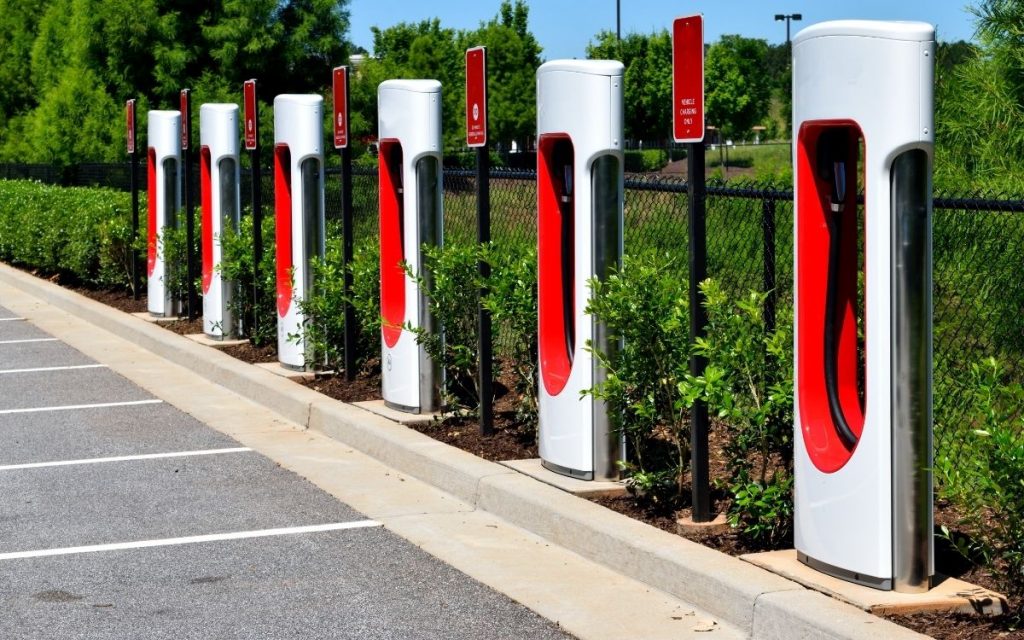 a row of electric car chargers sit in a row in front of empty parking spots 
