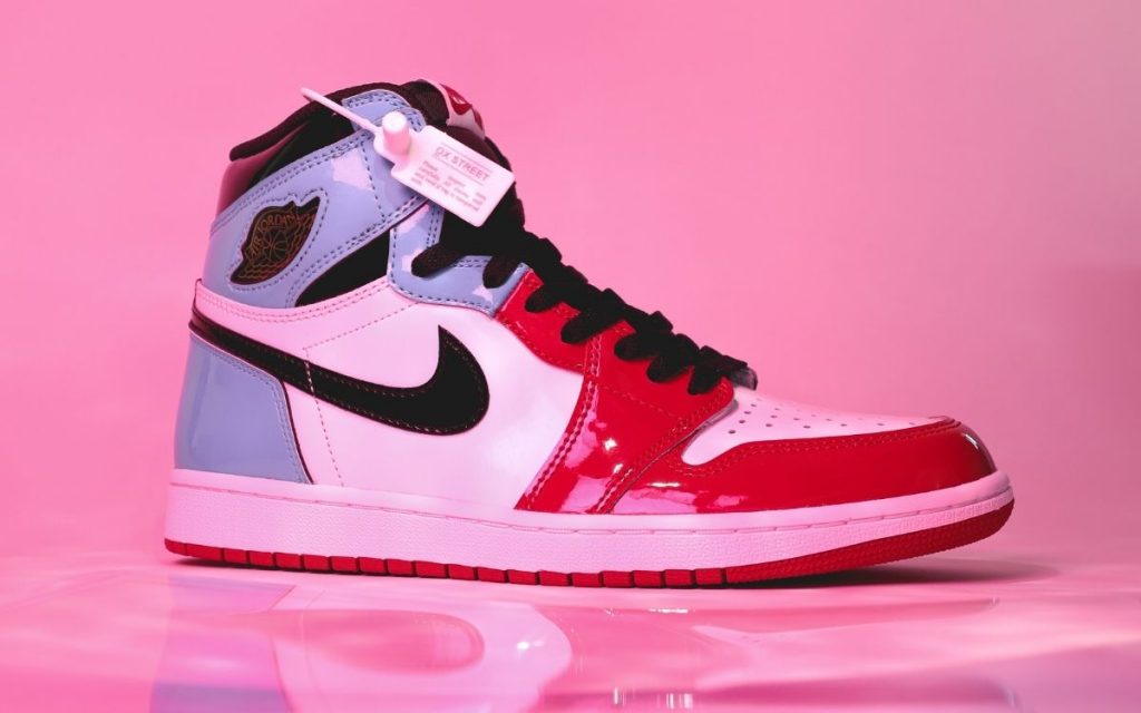 nike high top sneaker made of multiple materials against a pink reflective background