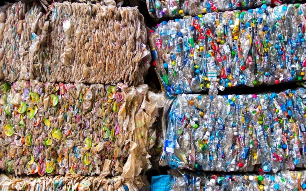 Plastic bottle and plastics bag bales sit on top each other.
