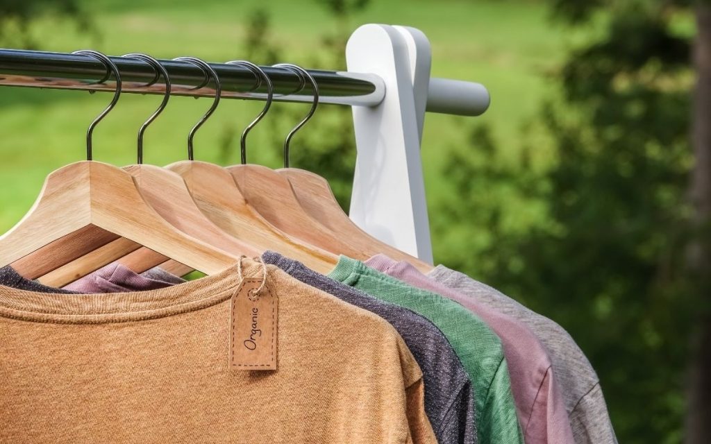 rack of organic clothing on hangers outside 
